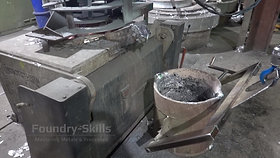 Pouring ladle on crane in front of furnace